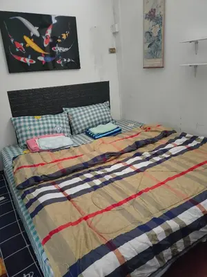 a bed with a colorful blanket and pillows on it at Sip N' Camp in Bangkok