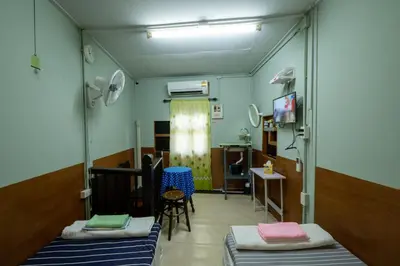 a hospital room with two beds and a tv at Sip N' Camp in Bangkok