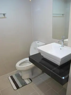 a bathroom with a white toilet and a sink at Delight Residence in Bangkok