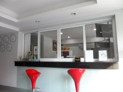 a kitchen with two red chairs at a counter at Delight Residence in Bangkok