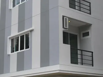 a white building with windows and a balcony at Delight Residence in Bangkok