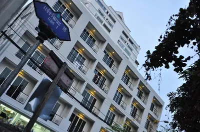 a street sign in front of a white building at Delight Residence in Bangkok