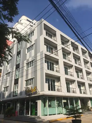a large white building with windows on a street at Delight Residence in Bangkok