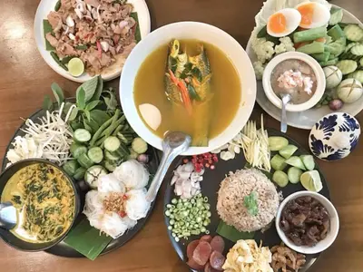 a table with a bowl of soup and a plate of food at Botanic Service Room at Impact Muangthongthani - SHA Certified in Nonthaburi