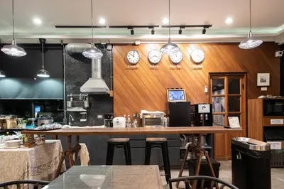 a restaurant with a bar with clocks on the wall at Botanic Service Room at Impact Muangthongthani - SHA Certified in Nonthaburi