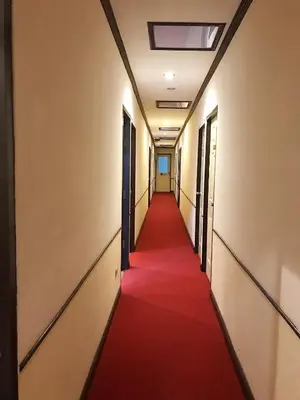a long corridor with a red carpet in an office building at Honey House1 hotel in Bangkok
