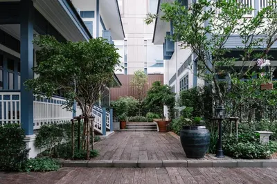 a courtyard with trees and plants in a building at Baan Vajra in Bangkok