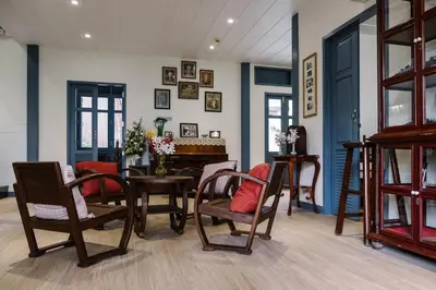 a dining room with chairs and a table and a room with blue walls at Baan Vajra in Bangkok