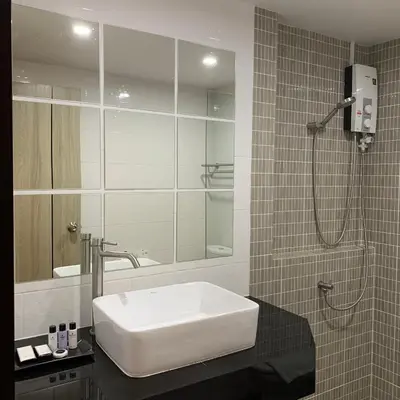 a bathroom with a white sink and a shower at Toptel Thaphra - ท็อปเทล ท่าพระ in Bangkok