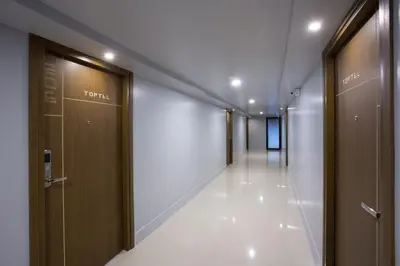 a corridor of a hospital hallway with wooden doors at Toptel Thaphra - ท็อปเทล ท่าพระ in Bangkok