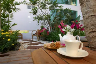 a cup of tea and a plate of food on a table at Bansabai Hostelling International in Bangkok