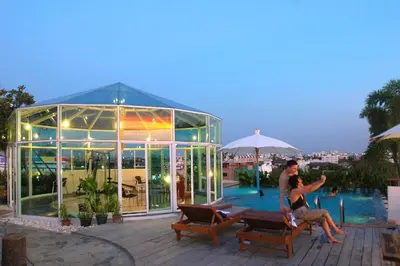 a man and a woman standing next to a glass house at Bansabai Hostelling International in Bangkok