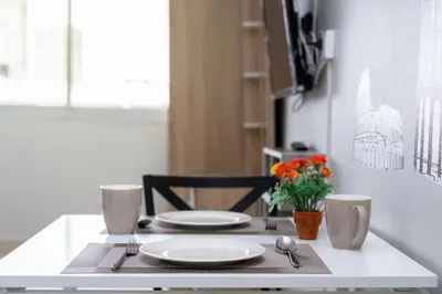 a table with plates and utensils on top of it at Popular Condo Muangthong by Khun Eve in Nonthaburi