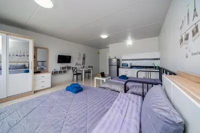 a large room with two beds and a kitchen at Popular Condo Muangthong by Khun Eve in Nonthaburi