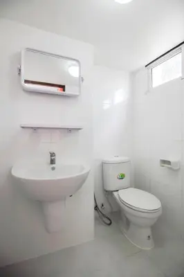 a white bathroom with a toilet and a sink at SLT Apartment Bangkok in Bangkok