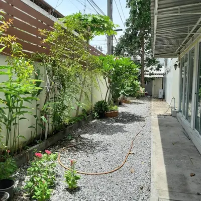 a garden outside a house with a garden hose at SLT Apartment Bangkok in Bangkok
