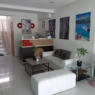 a living room with a white couch and tables at SLT Apartment Bangkok in Bangkok