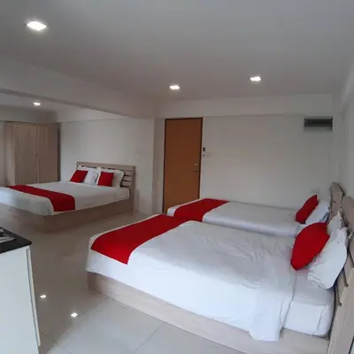 a bedroom with two beds with red and white pillows at SLT Apartment Bangkok in Bangkok