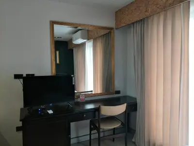 a desk with a television and a chair in a room at The 92 Residence in Bangkok