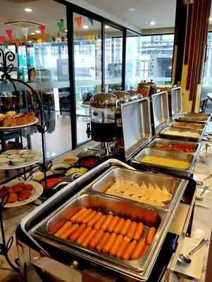 a buffet line with hot dogs and other food at Siri Oriental Bangkok Hotel in Bangkok