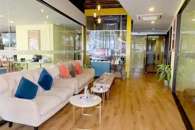 a living room with a white couch and blue pillows at Siri Oriental Bangkok Hotel in Bangkok