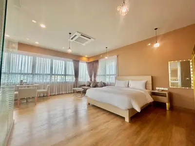 a large bedroom with a bed and a living room at Siri Oriental Bangkok Hotel in Bangkok