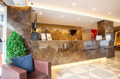 a lobby with a chair and a christmas tree at Spittze Hotel Pratunam in Bangkok