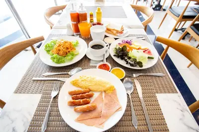 a table with three plates of food on it at Spittze Hotel Pratunam in Bangkok
