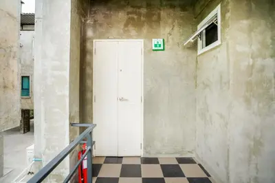 a white door in a room with a checkered floor at Matini Ratchada 32 in Bangkok