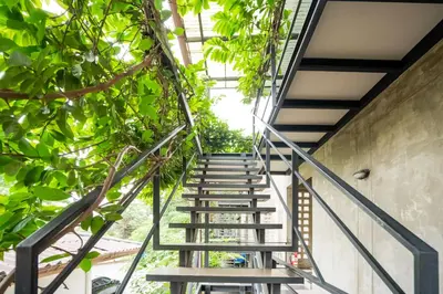 a staircase in a building with green plants at Matini Ratchada 32 in Bangkok