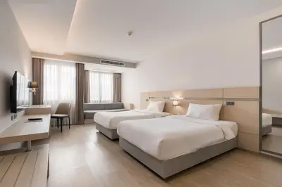 a hotel room with two beds and a television at Samyan Serene Hotel in Bangkok