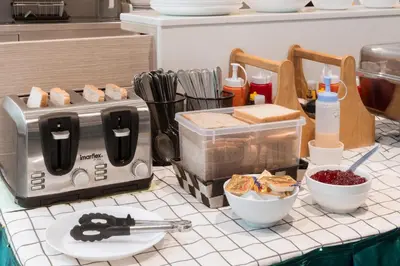 a kitchen counter with a toaster and some food at Samyan Serene Hotel in Bangkok