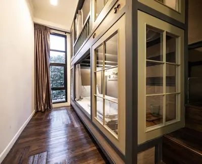 a room with large windows and wooden flooring at Warm Window Silom in Bangkok