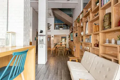 a room with wooden shelves and a couch and a table at Simply Sleep Hostel in Bangkok