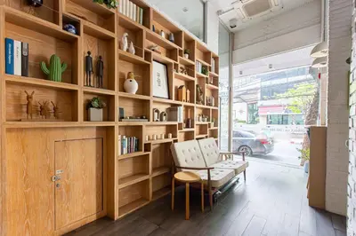 a room with wooden shelves and a chair and a window at Simply Sleep Hostel in Bangkok
