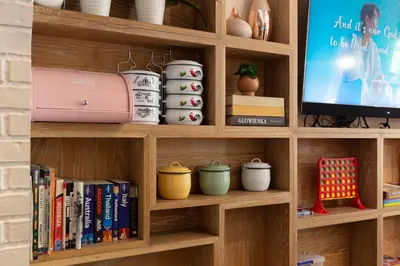 a book shelf with books and a tv at Simply Sleep Hostel in Bangkok