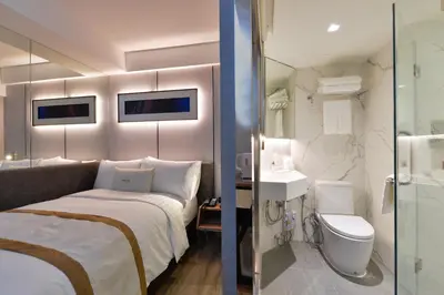 a hotel room with a bed and a toilet at Syama Nana in Bangkok