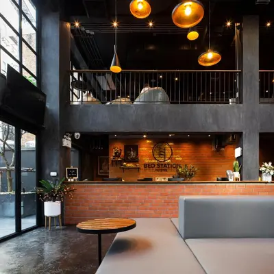 a restaurant with a brick wall and a table at BED STATION Hostel Khaosan in Bangkok