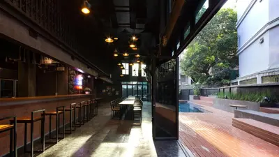 a view of a bar with a table and chairs at BED STATION Hostel Khaosan in Bangkok