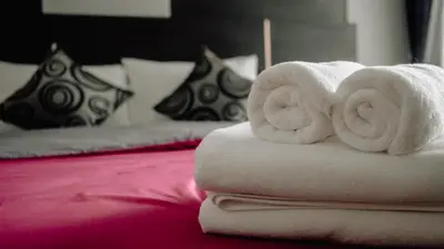 a pile of towels sitting on top of a bed at Step One at Bangkok in Bangkok
