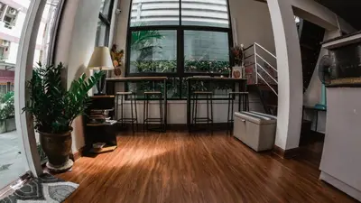 a hallway with stools and a large window with plants at Step One at Bangkok in Bangkok