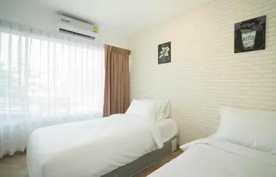 a hotel room with two beds and a window at The Lux Ladprao 10 in Bangkok