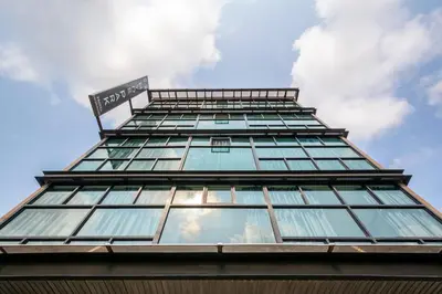 a tall glass building with a sign on it at Hyde Park Hotel Bangkok in Bangkok