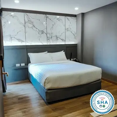 a bedroom with a large bed with a marble headboard at Hyde Park Hotel Bangkok in Bangkok