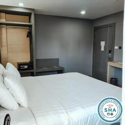 a bedroom with a large white bed with pillows at Hyde Park Hotel Bangkok in Bangkok