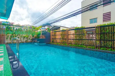 a swimming pool next to a fence and a building at Penyos Residence in Bangkok