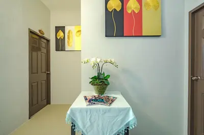 a table with a vase with white flowers on it at Penyos Residence in Bangkok