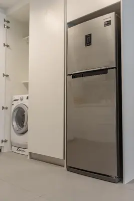 a refrigerator in a kitchen next to a washing machine at Alix Bangkok Hotel in Bangkok