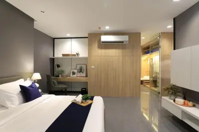 a bedroom with a large white bed and a desk at Alix Bangkok Hotel in Bangkok
