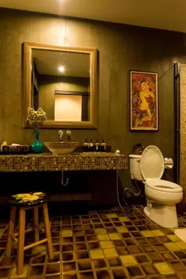 a bathroom with a toilet and a sink and a mirror at Arun Residence in Bangkok